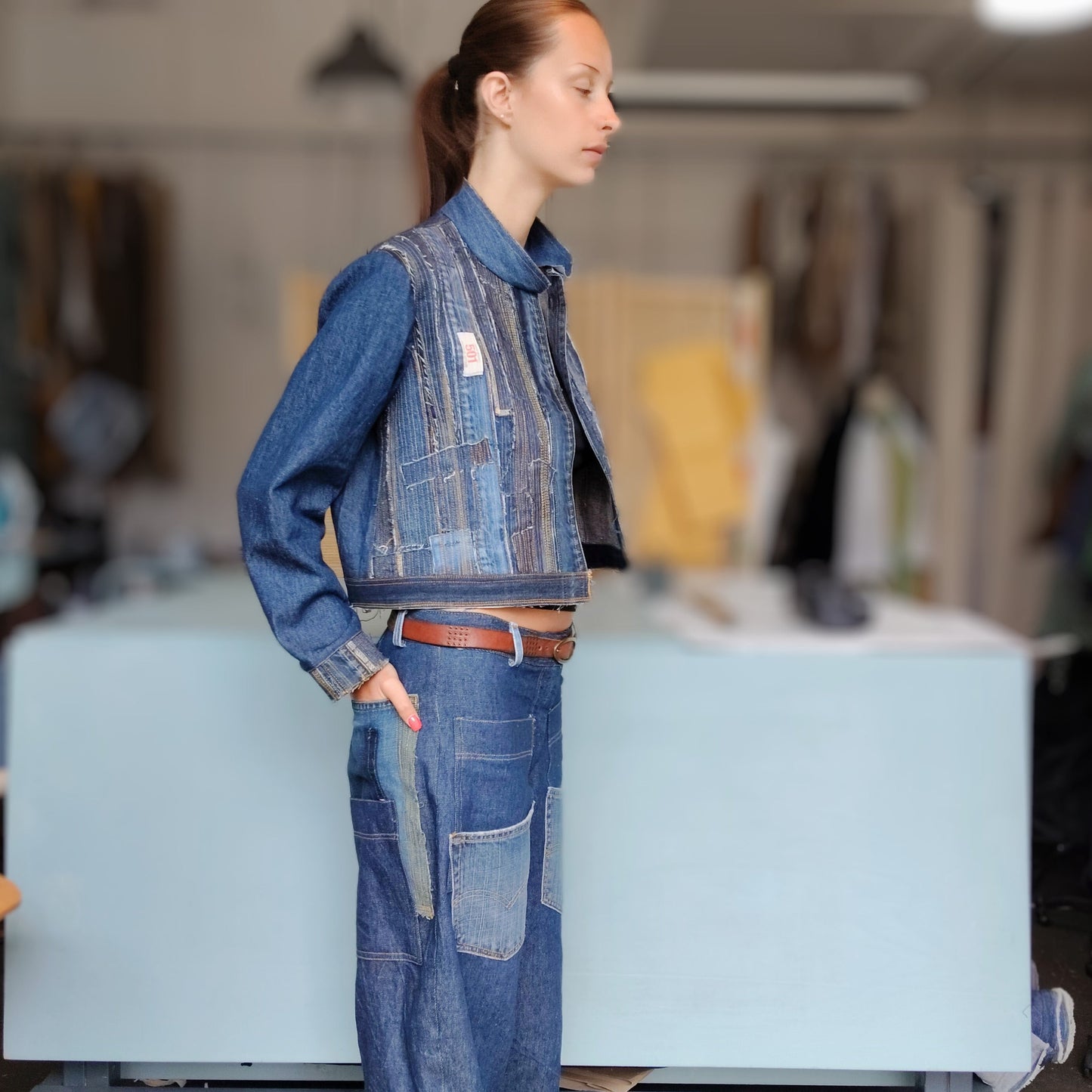 Person wearing a denim outfit in a workshop setting