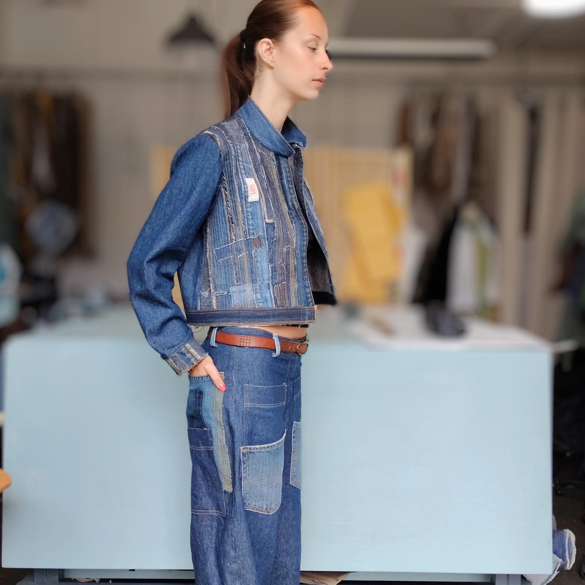 Person wearing a denim outfit in a workshop setting